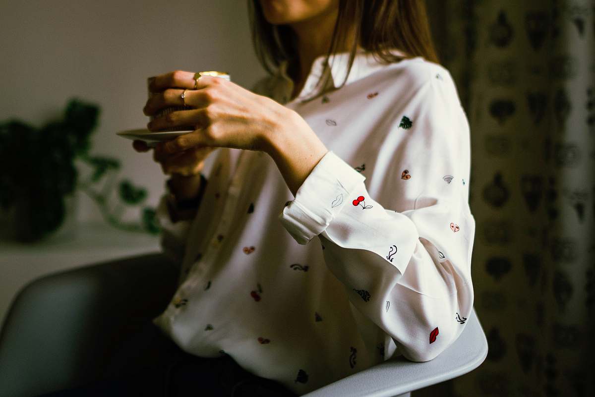 people woman in white long-sleeved collared shirt holding teacup human