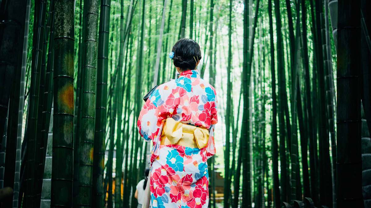 kimono woman standing in front of trees japan