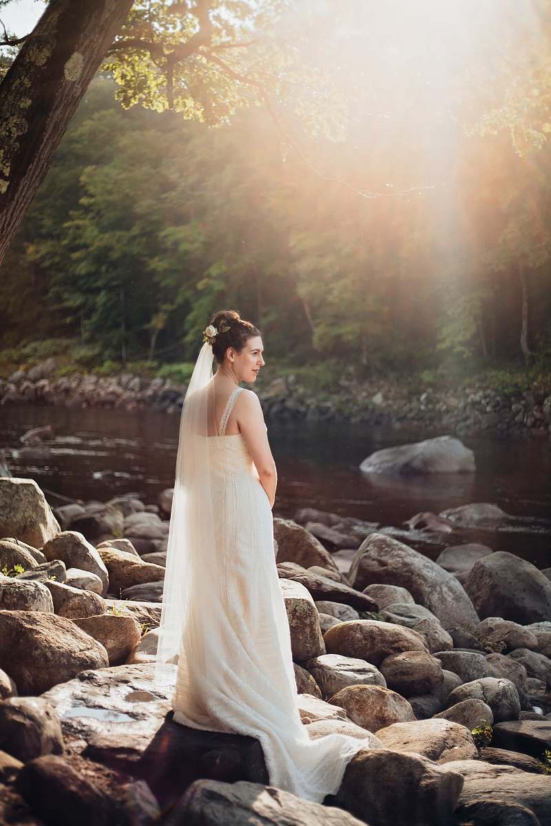 nature woman standing on gray rock near lake during sunset rock