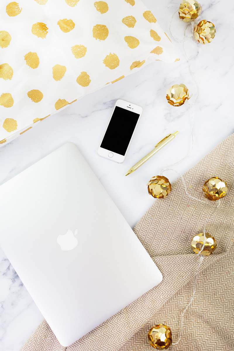 electronics gold iPhone beside pen on white textile mobile phone