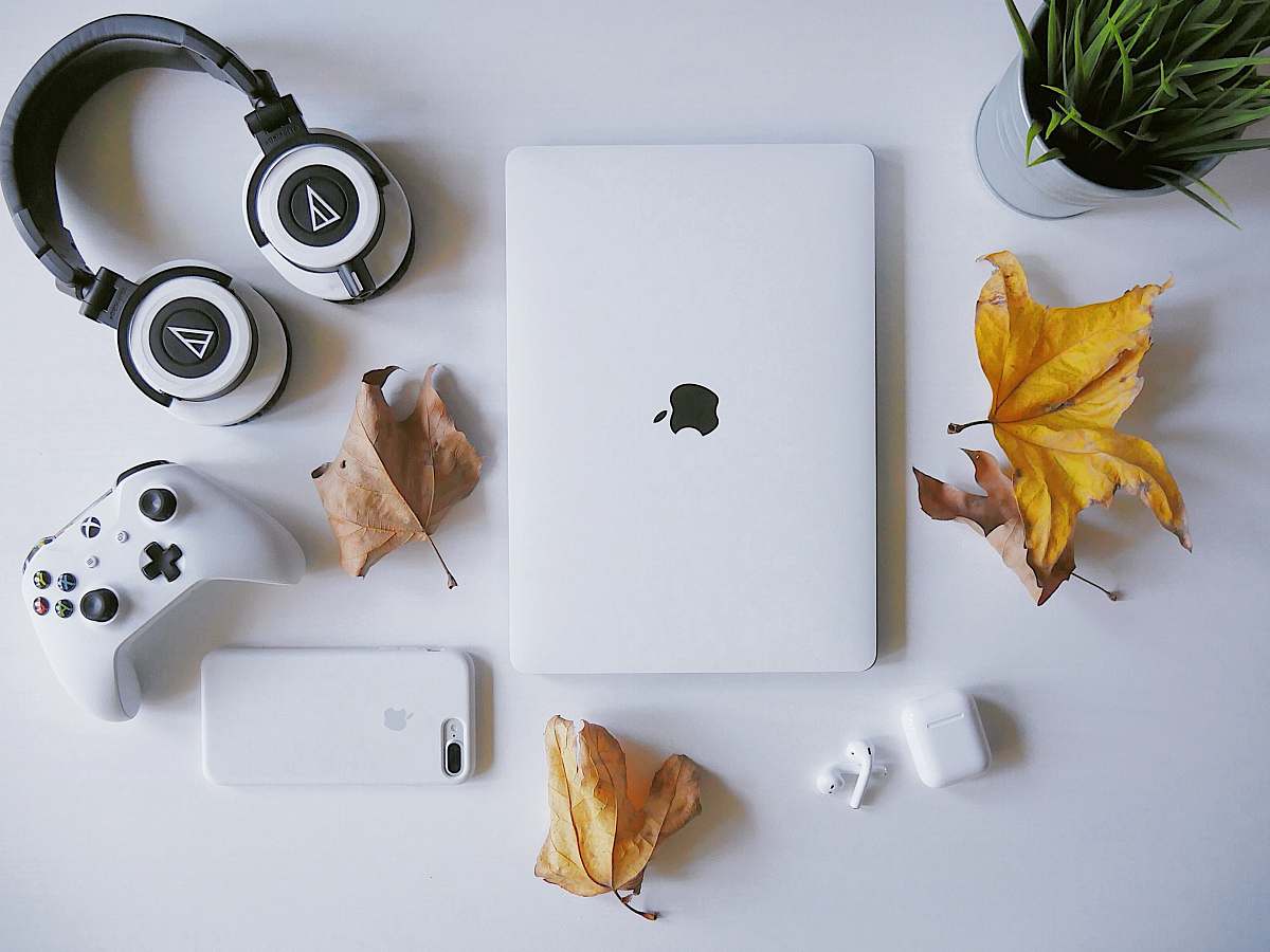 flora MacBook beside headphones potted plant