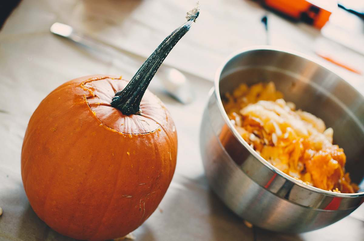 pumpkin orange squash on table beside steel bowl food