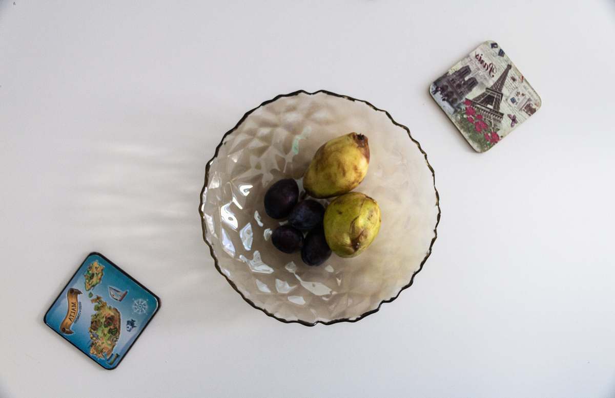 food round clear glass bowl fruits on the white table