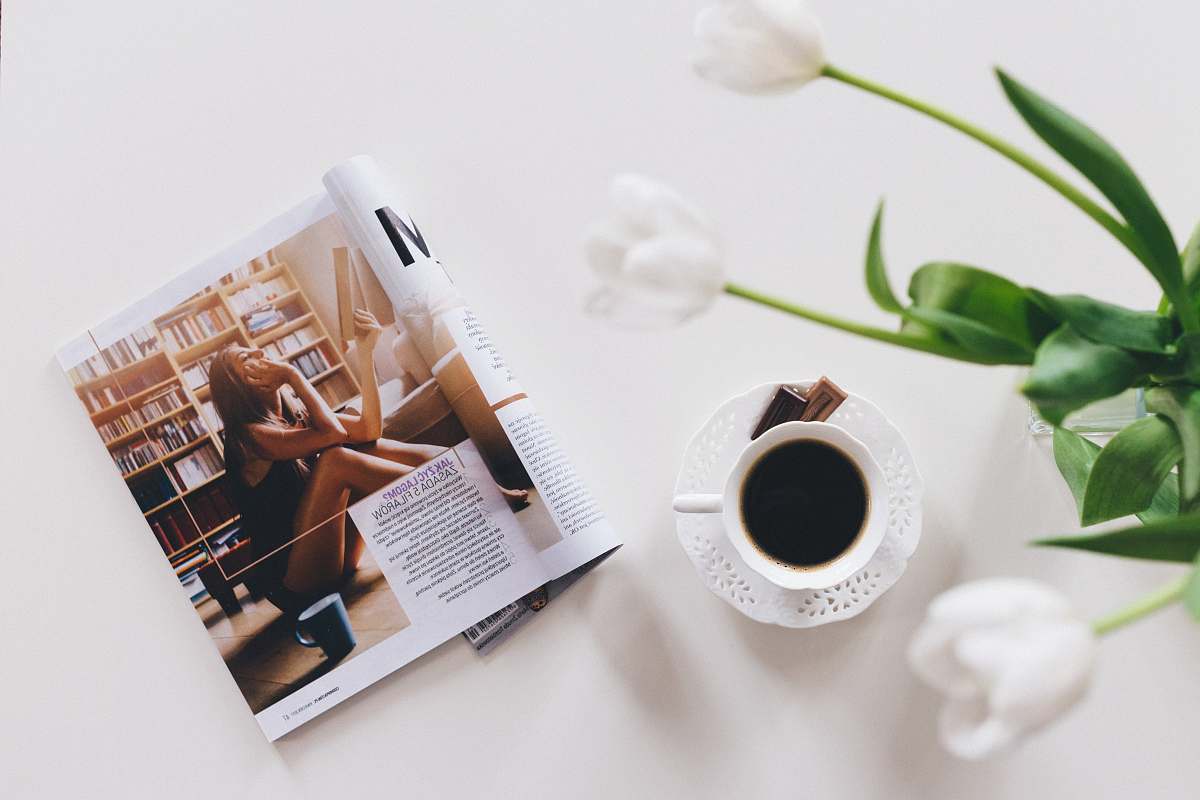 flower top view of opened magazine near up of coffee vase