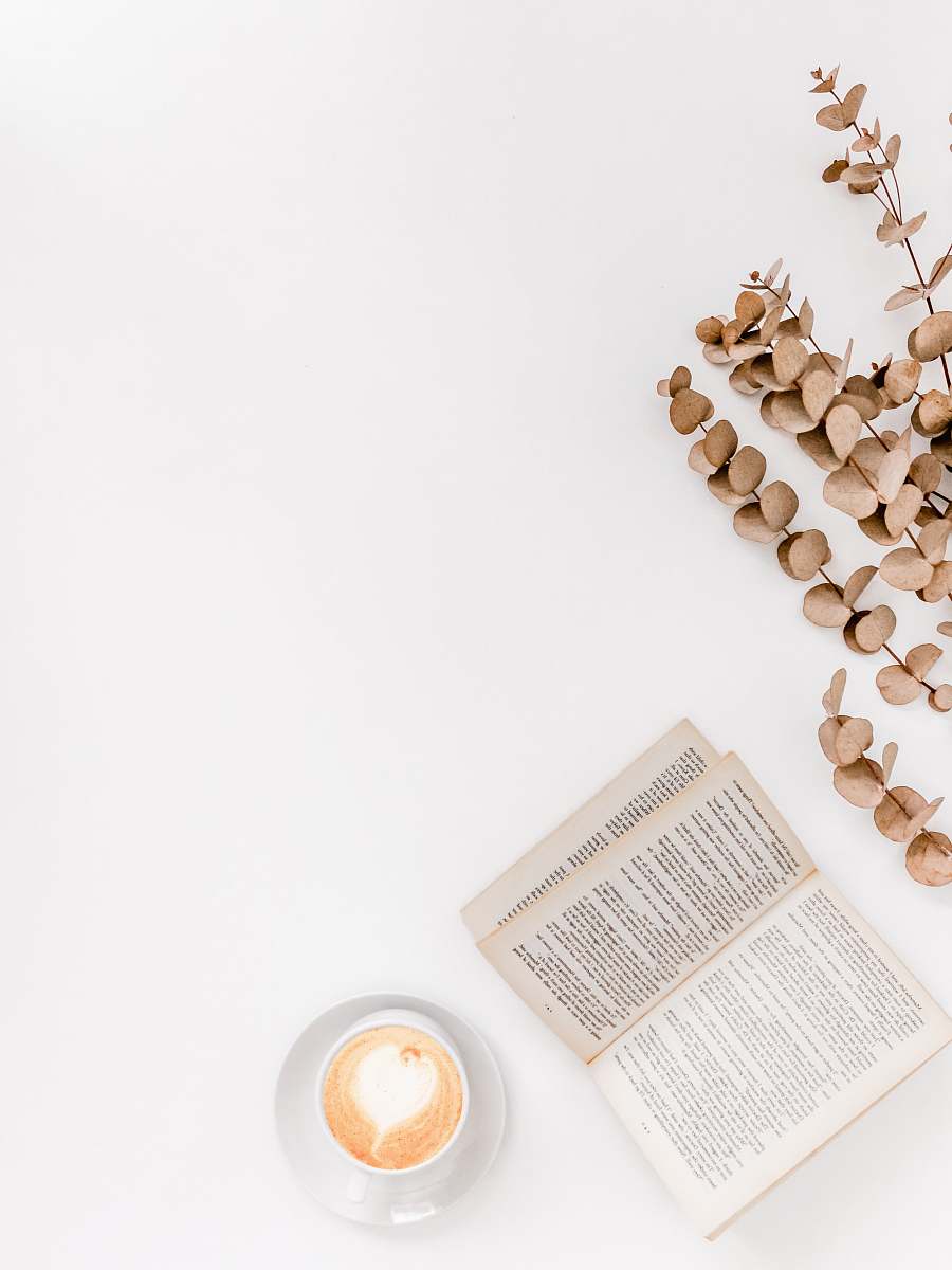 reading white ceramic mug beside white book white