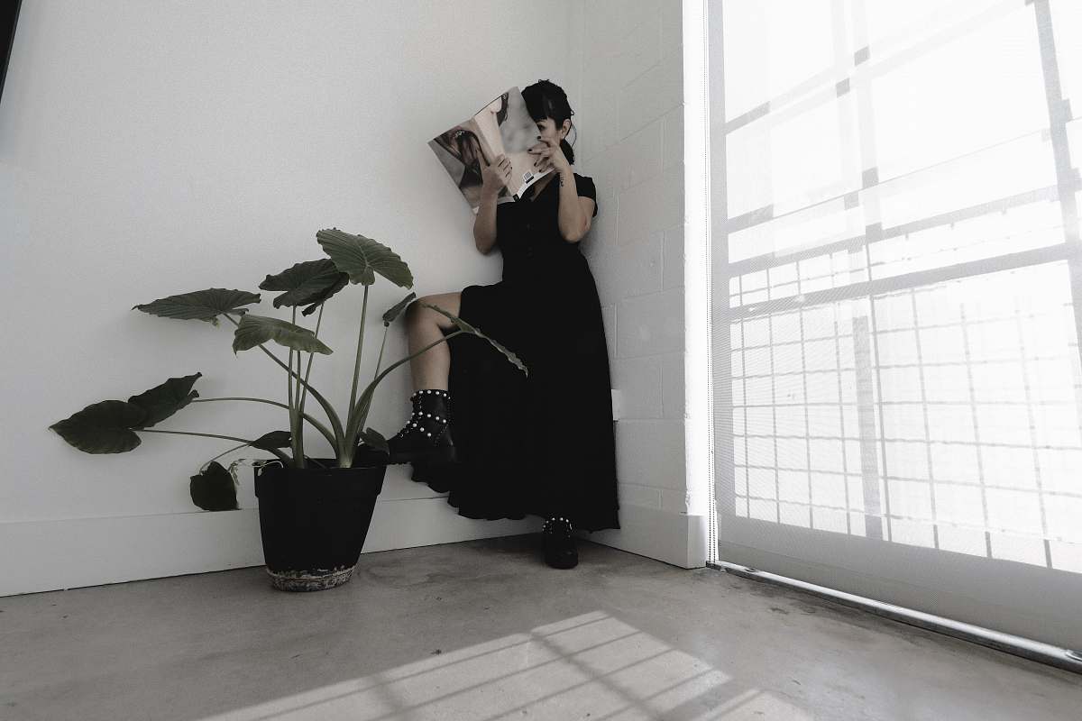 flora woman in black dress reading book jar