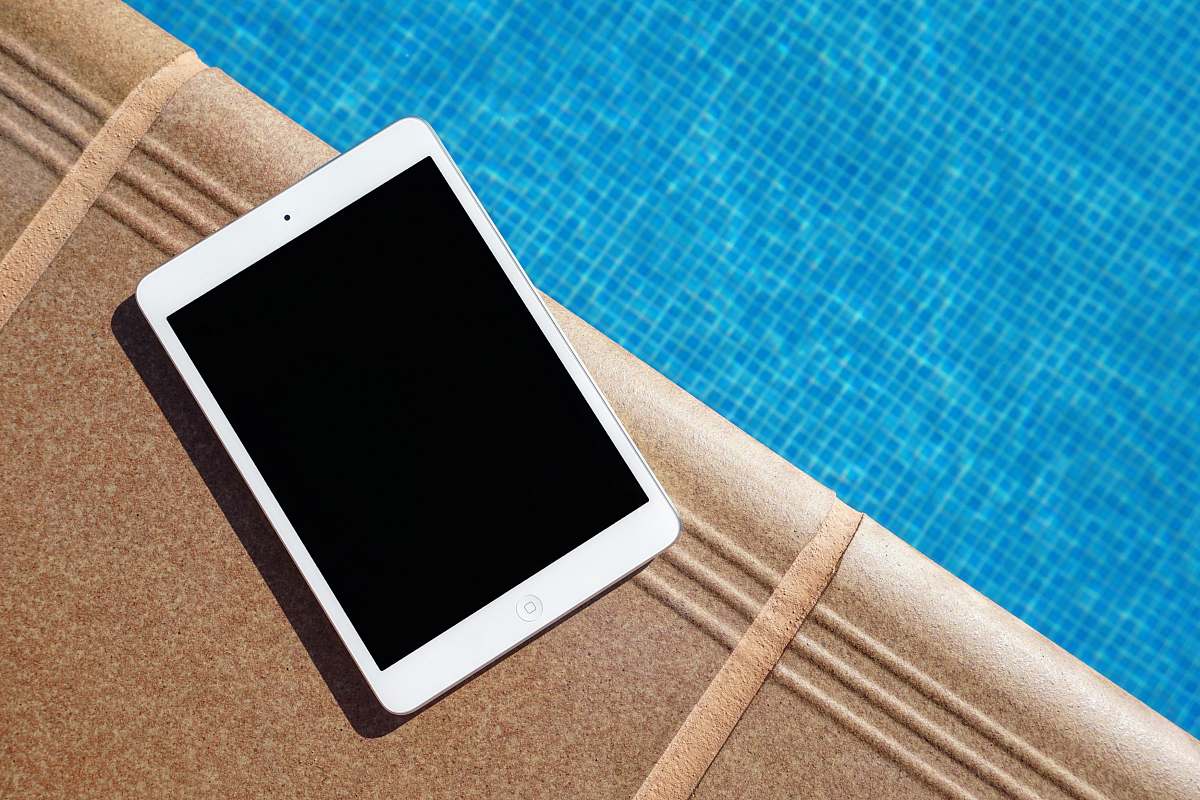 tablet white iPad beside swimming pool tech