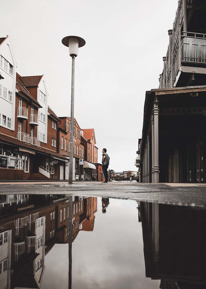juist low-angle photography of man standing light post germany