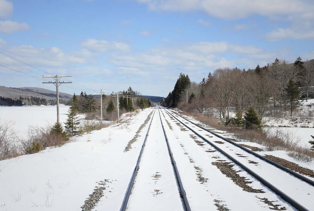 rail railway covered with snow under cloudy sky train track