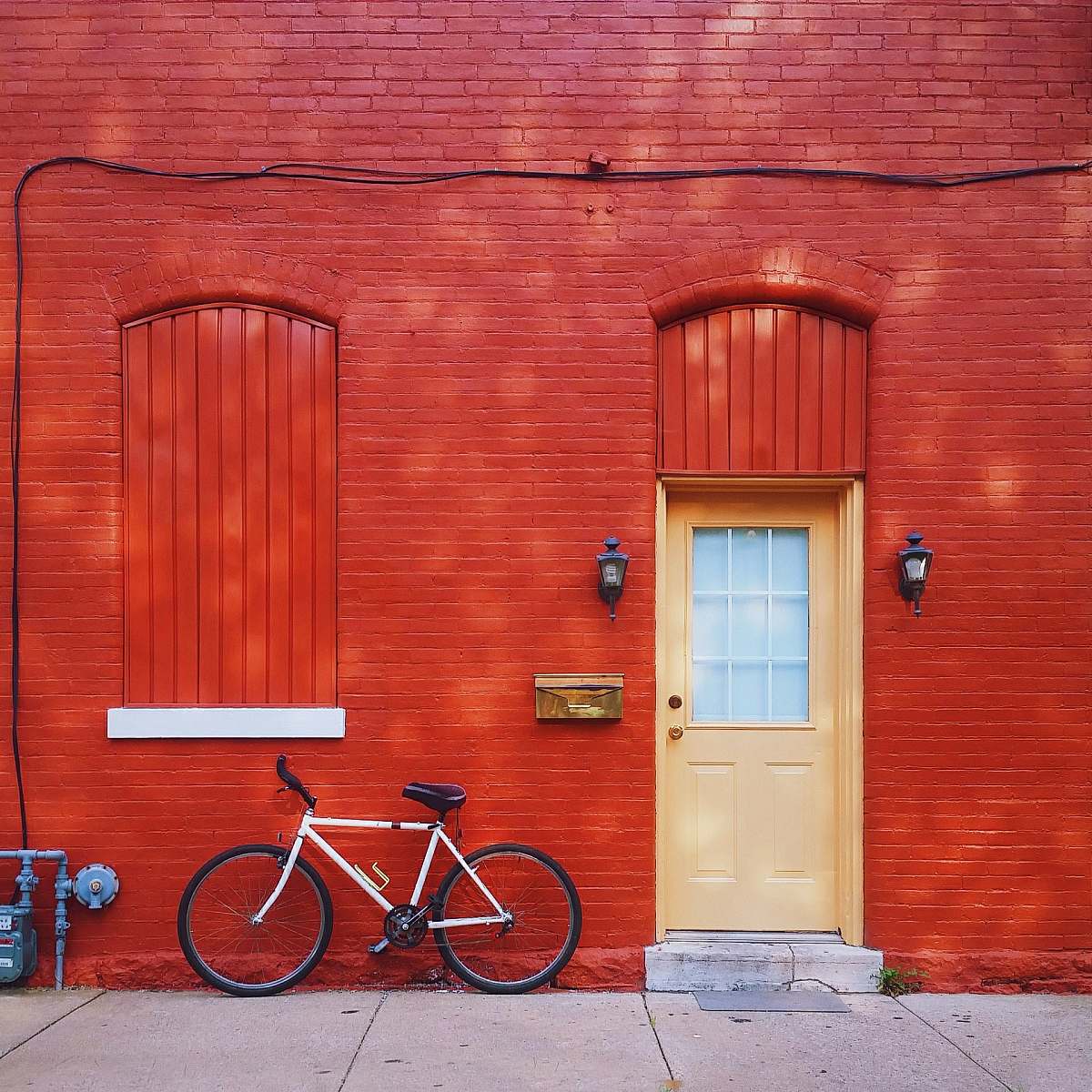 brick white bicycle parked beside wall background