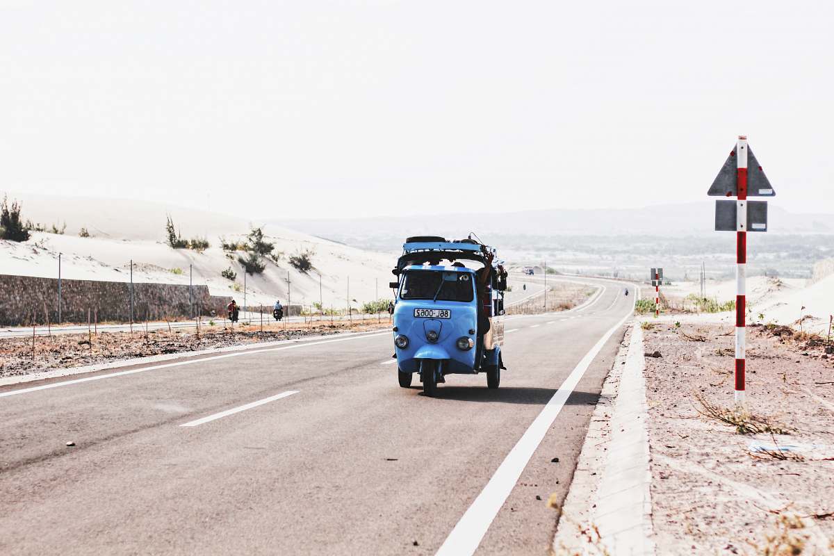 sign blue auto-rickshaw beside road signage uphill