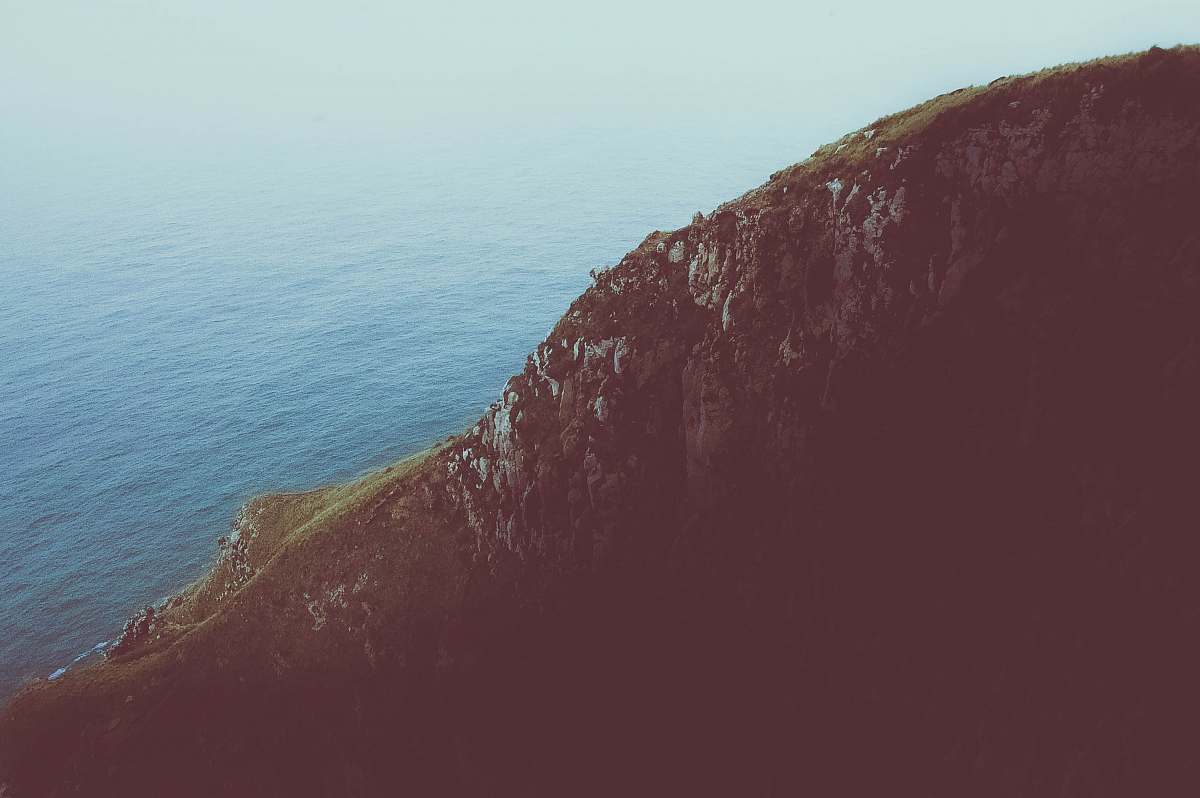 cliff photo of cliff near calm sea during daytime new zealand