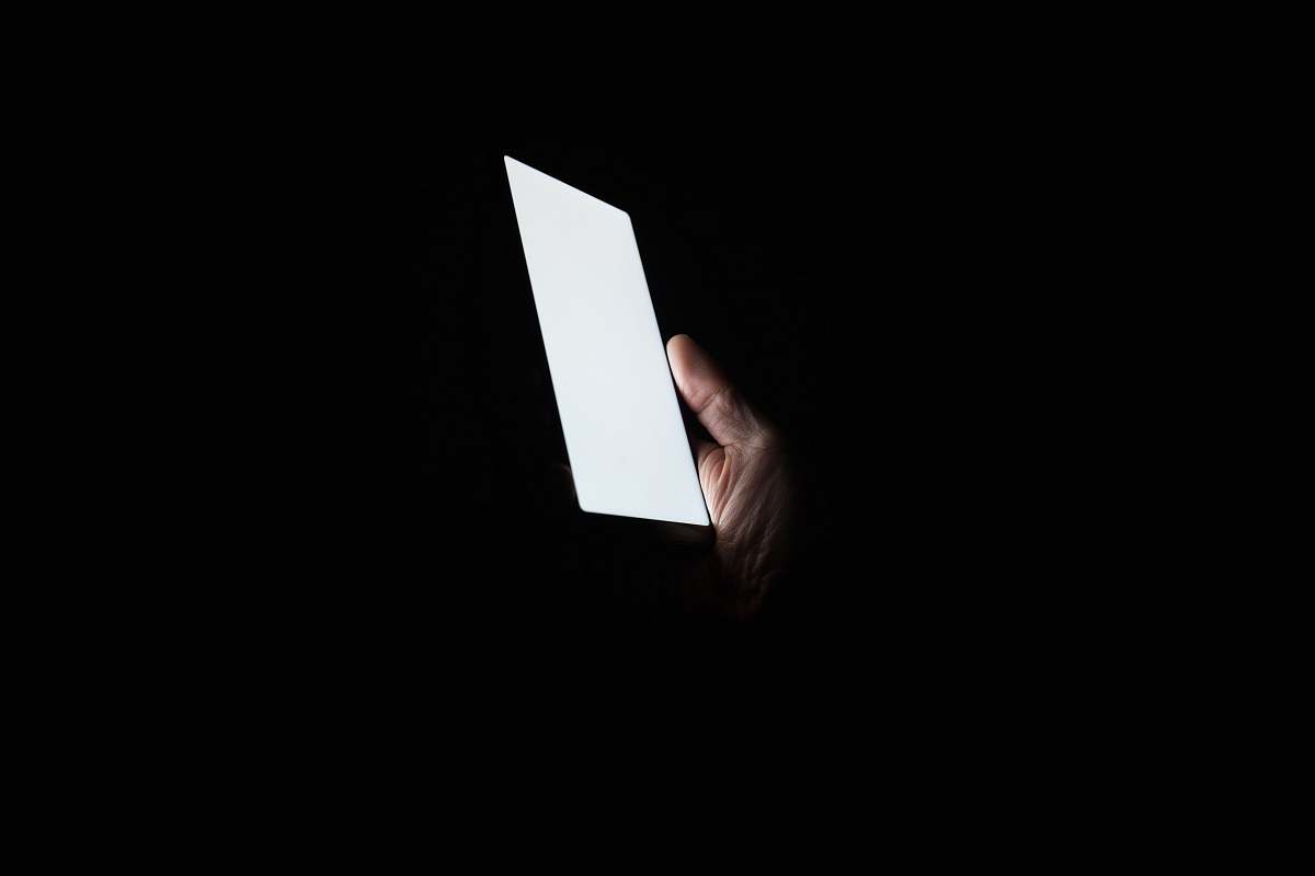 china person holding smartphone at night screen