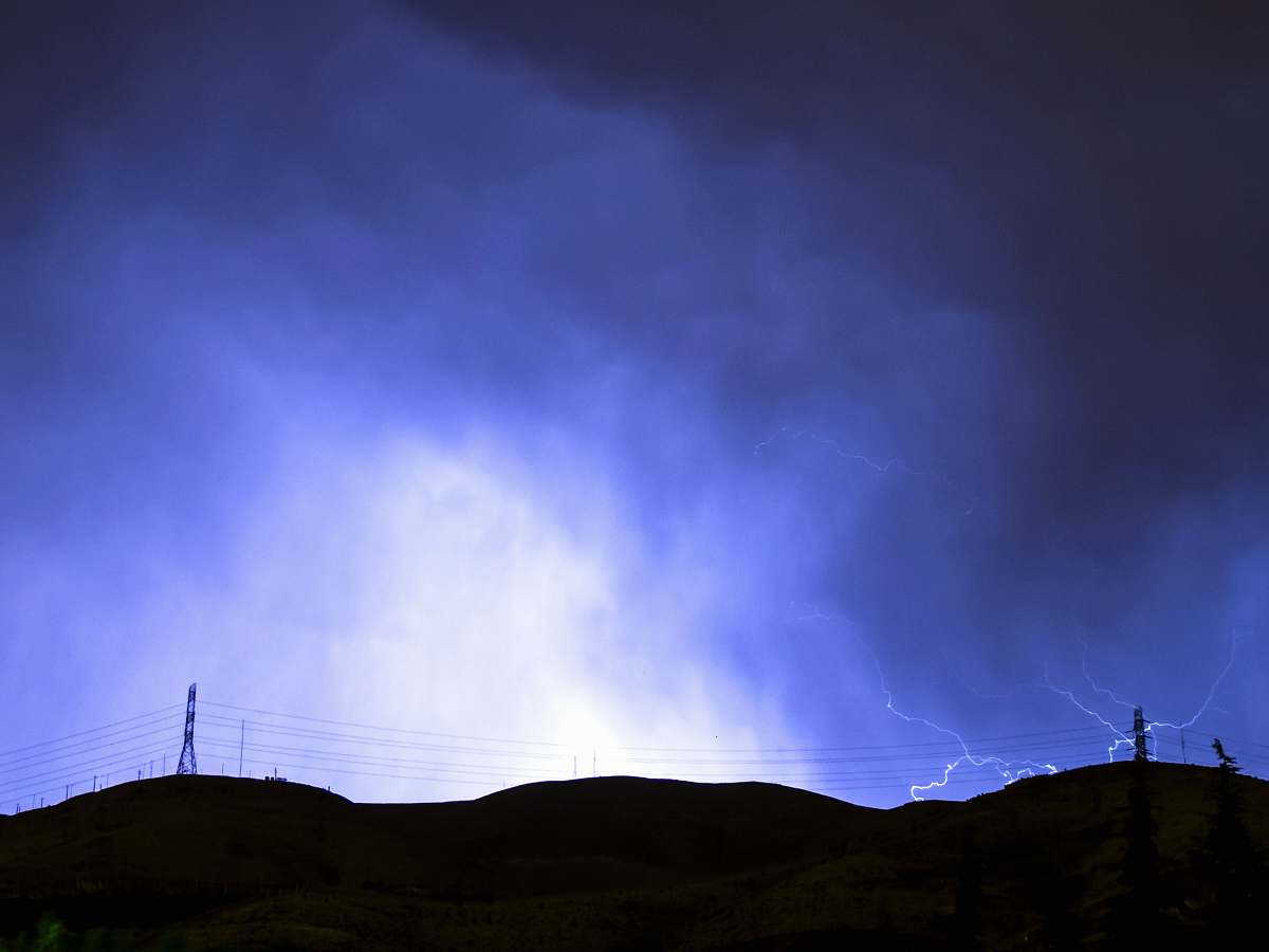 blue black mountain with purple thunderstorm during night time lightning