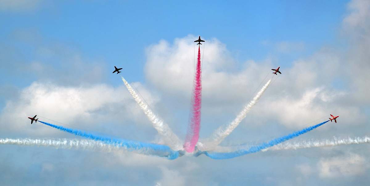 blue five assorted-color airplane sky show during daytime smoke