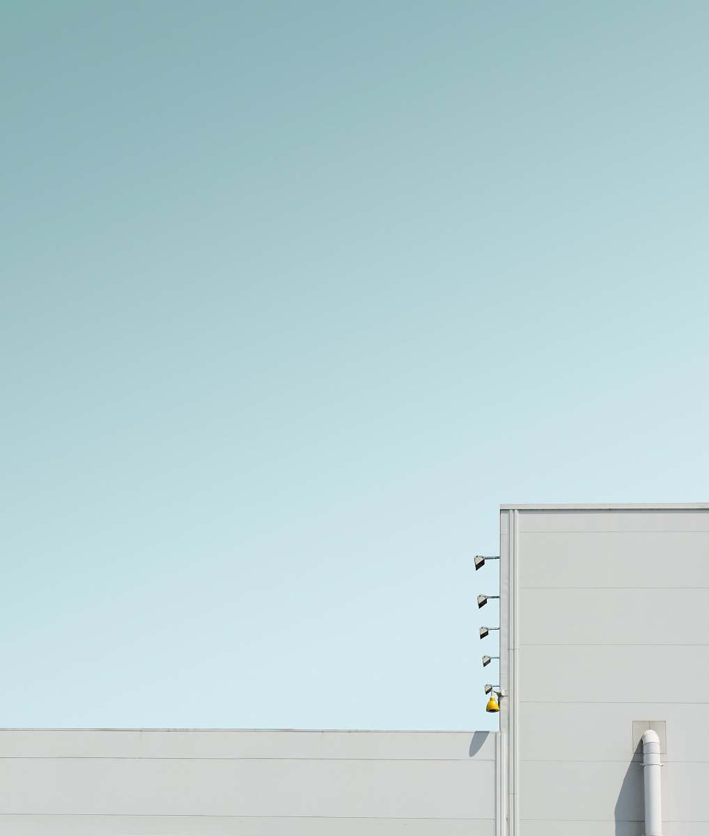 modern white concrete building under blue sky geometric