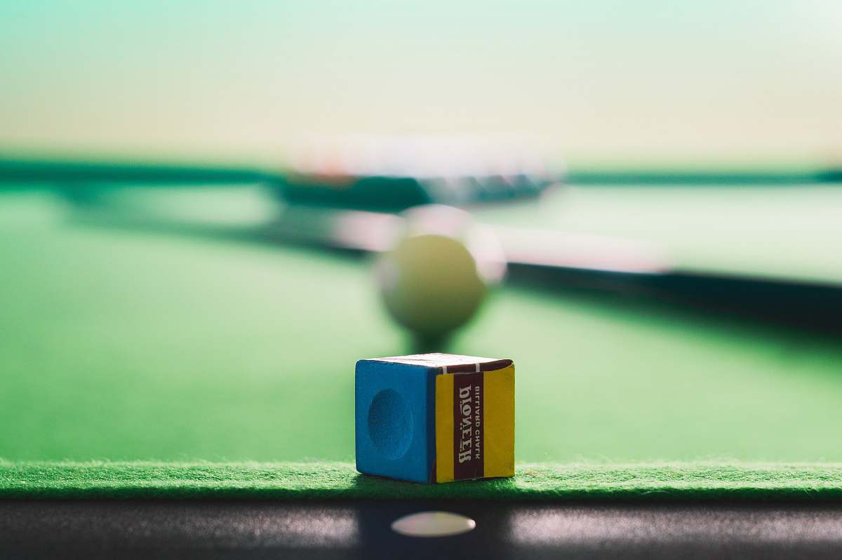 chalk yellow and blue cue stick chalk on green and black pool table blue