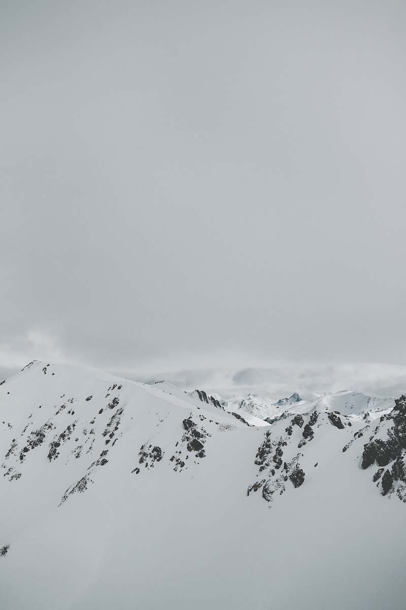 grey aerial photography of snow covered mountain peak winter