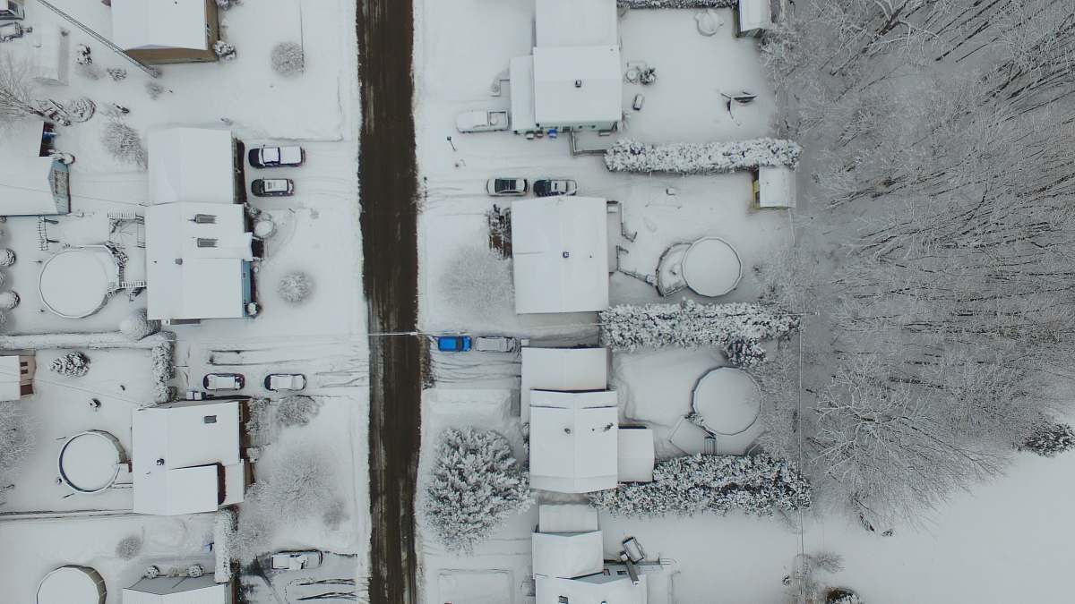 grey birds eye photography of snow covered residential area aerial view