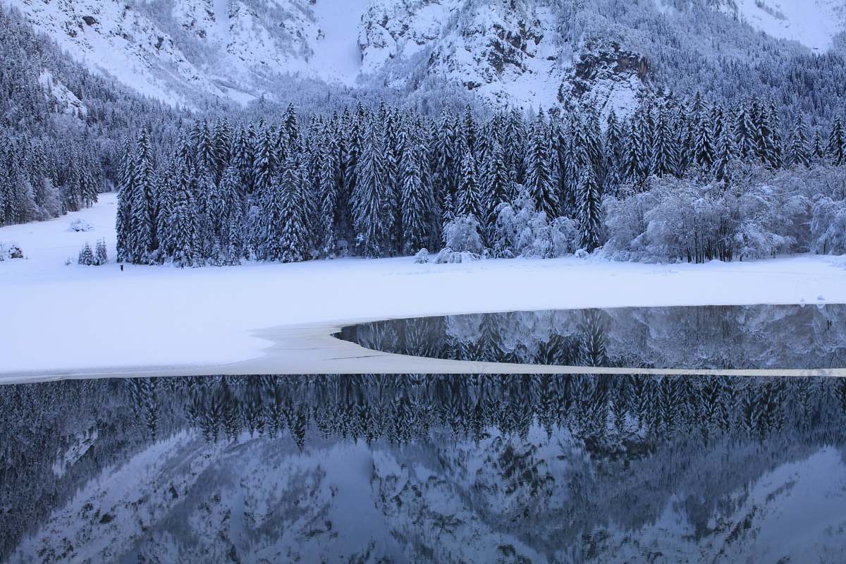 ice body of water near snow coated land mountain