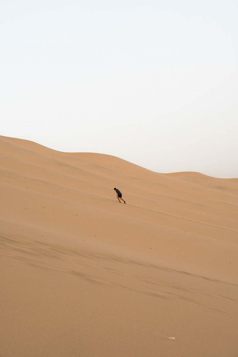 nature man climbing sand dunes outdoors