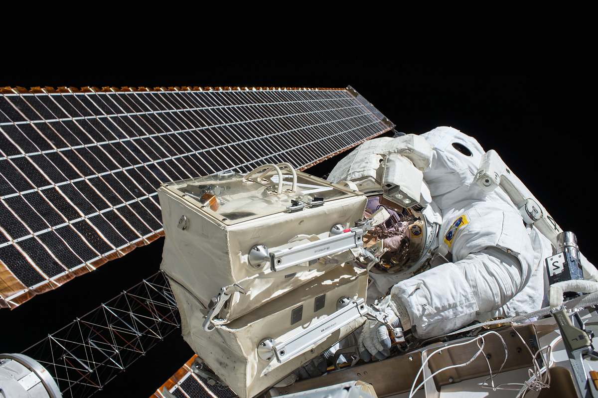 nasa closeup photo of astronaut repairing satellite astronaut