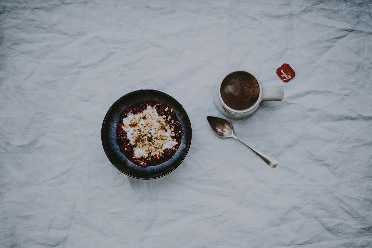 coffee white ceramic mug filled with brown liquid beside stainless steel spoon drink