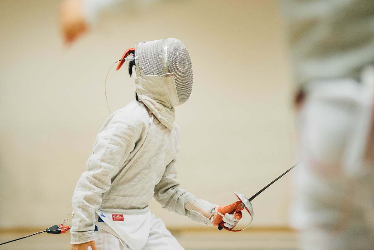 person person holding black sabre dagger fencing