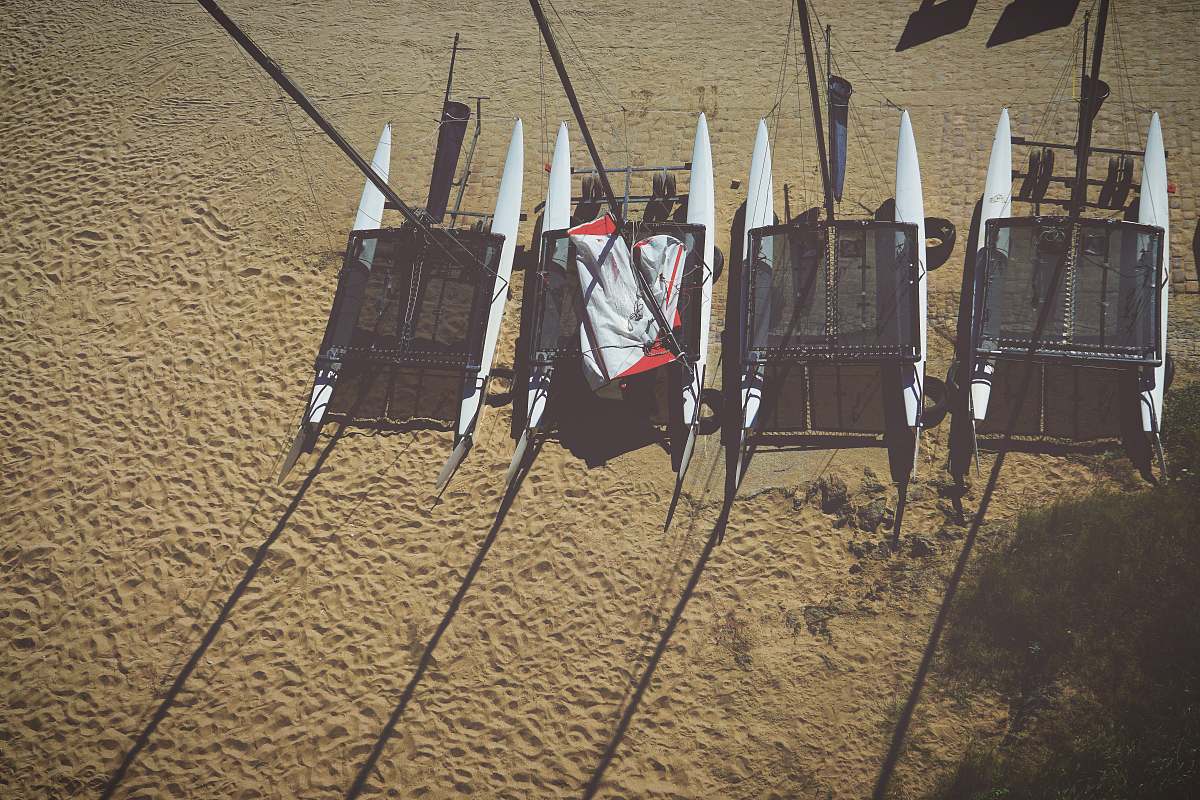 sail four white pontoon boats on beige sand sailboat