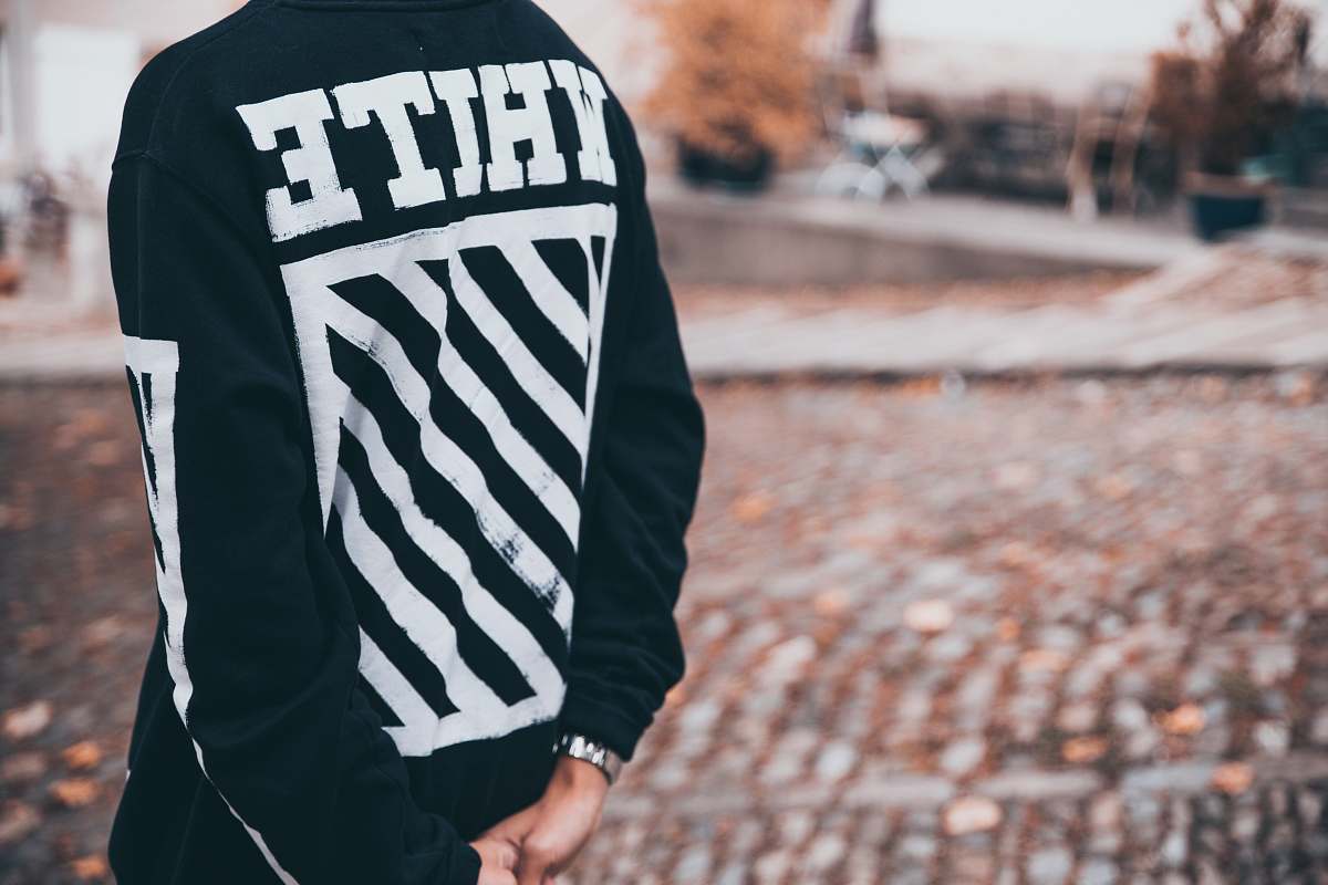 clothing person with white and black sweater standing on concrete road hoodie