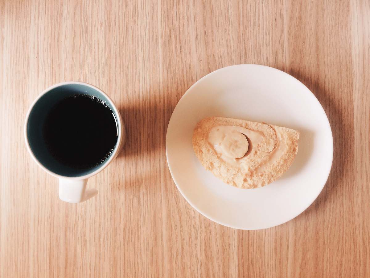 cup mug full of black coffee near a slice of cake coffee cup