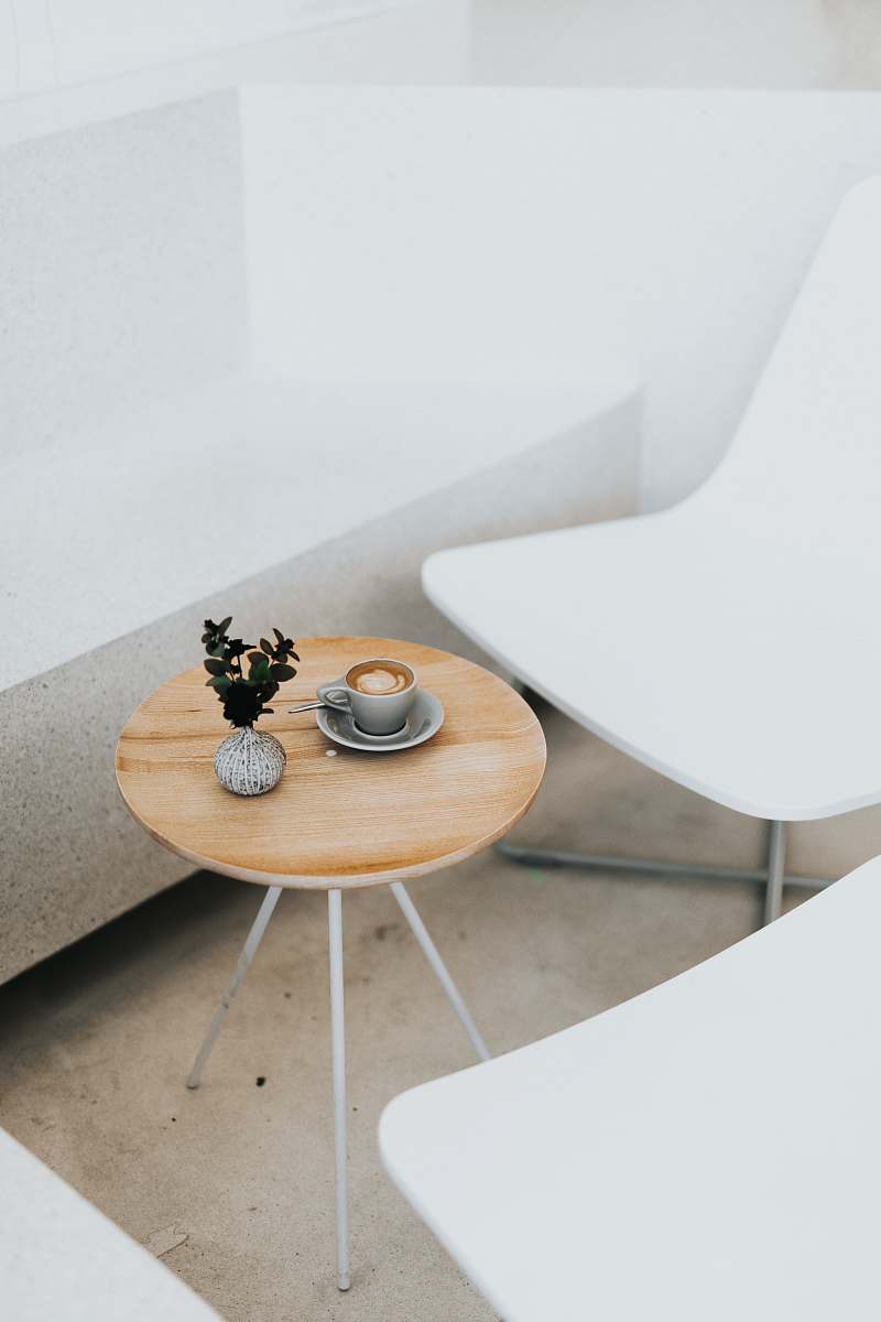 furniture round brown table beside two white chairs coffee table