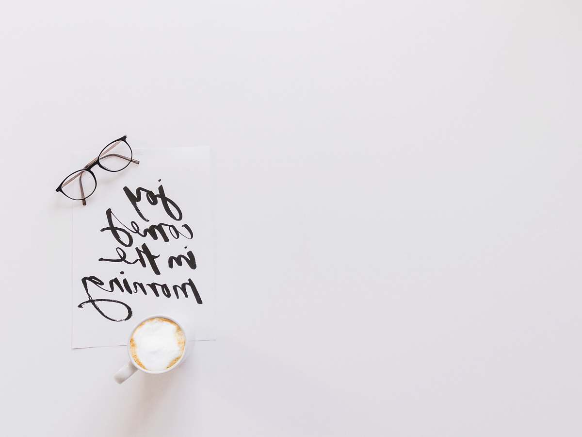 handwriting brown eyeglasses and latte on top of joy comes in the morning note white