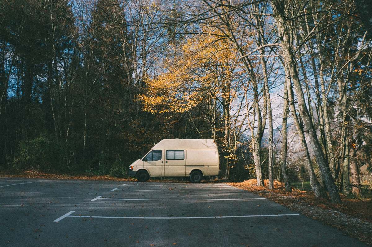 van white minivan parked near trees at daytime vehicle