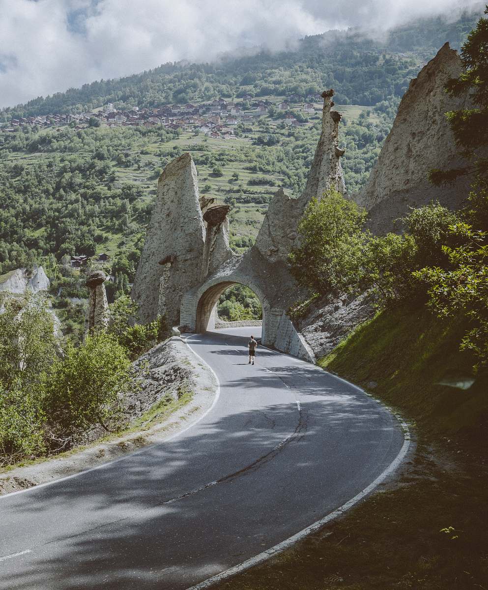 switzerland man walking on road near arch road