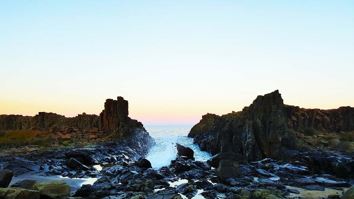 ocean landscape photography of body of water with rock formation cliff