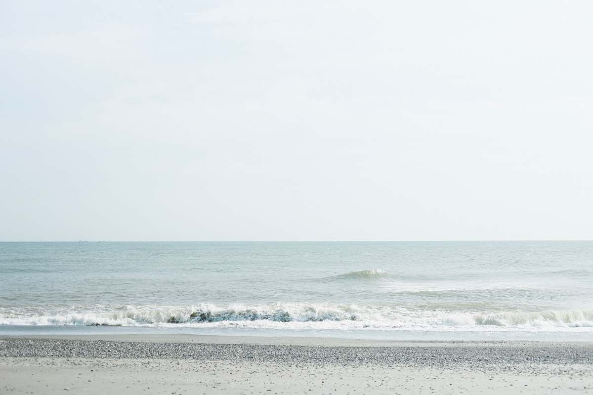 Experience the tranquility of nature with this stunning image of a woman in a flowing white dress standing gracefully on the beach. The powerful ocean waves crash against the shore, creating a picturesque backdrop that evokes a sense of peace and freedom. Perfect for travel blogs, lifestyle magazines, or inspirational quotes, this photograph captures the beauty of the sea and the elegance of coastal living.