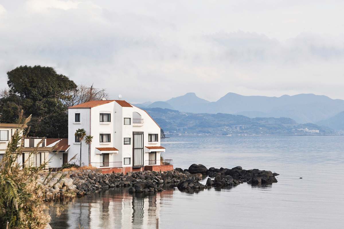 outdoors white and brown house at lakeside under grey cloudy sky architecture