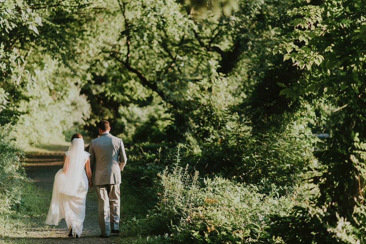 bride groom and bride walking on forest pathway photograph suit