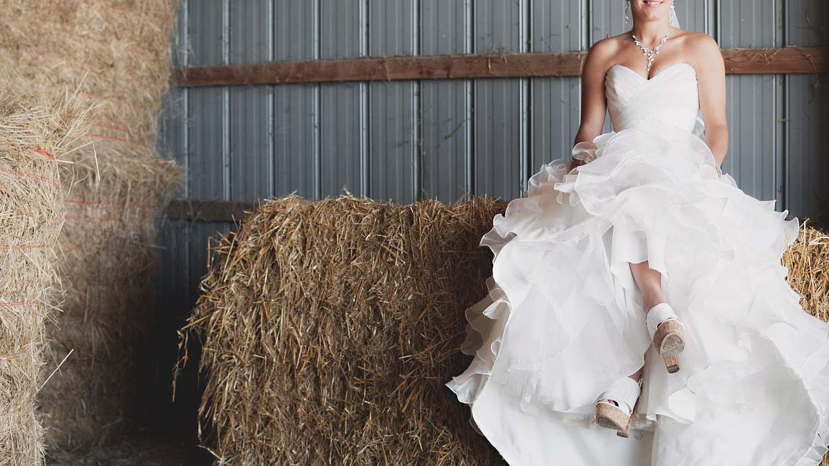 person woman in ruffled wedding gown sitting on haystack human