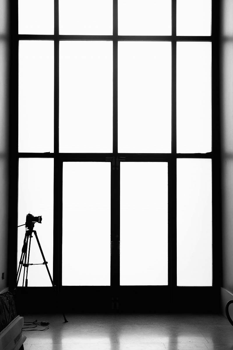 black-and-white grayscale photography of tripod and camera tripod