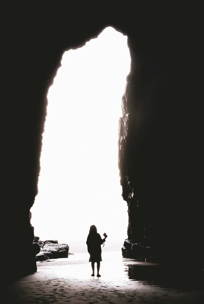 silhouette person standing in cave cathedral cave