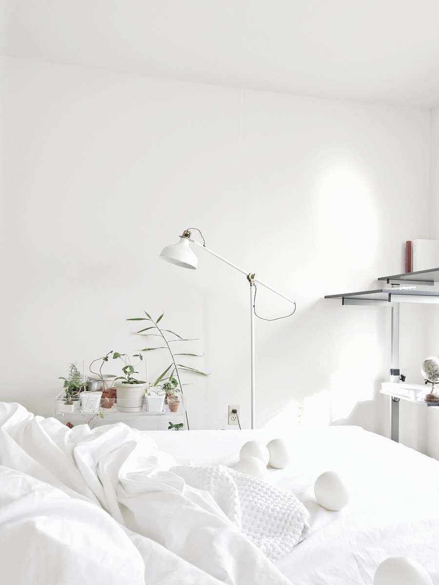 grey powered-off floor lamp beside comforter interior