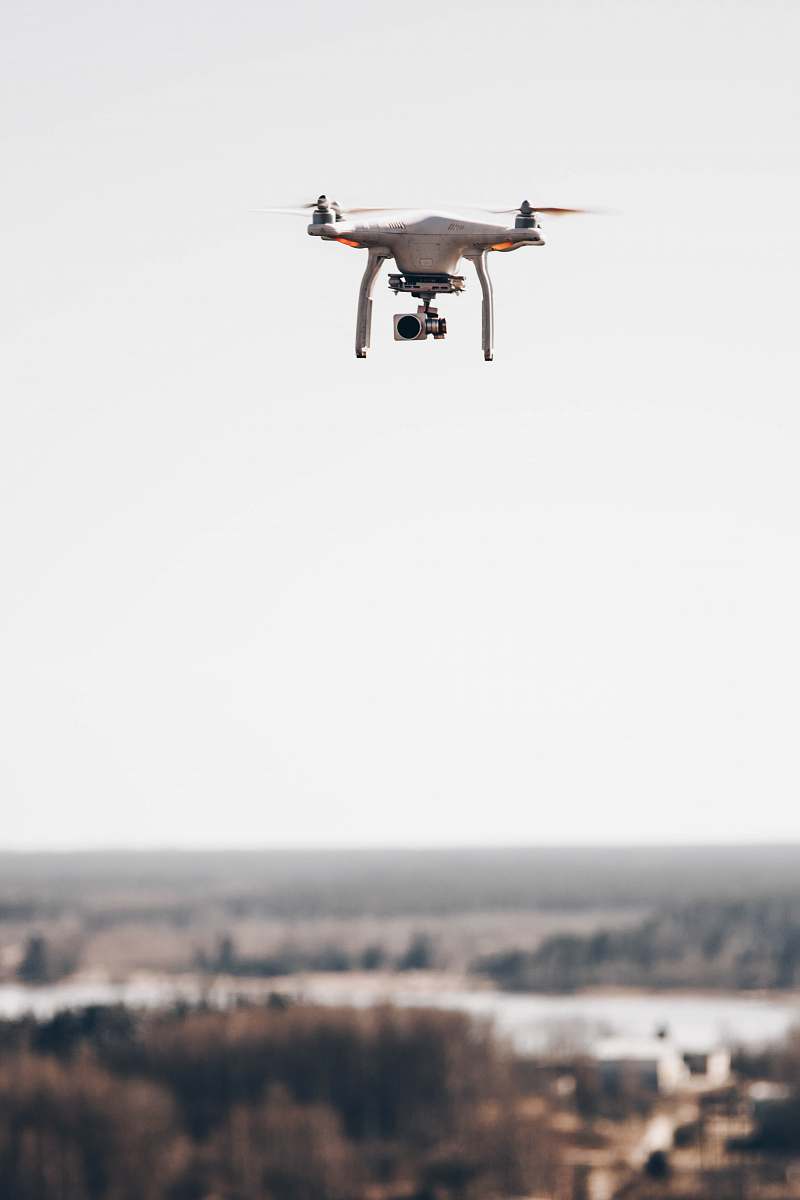 fly shallow focus photo of gray drone camera drone