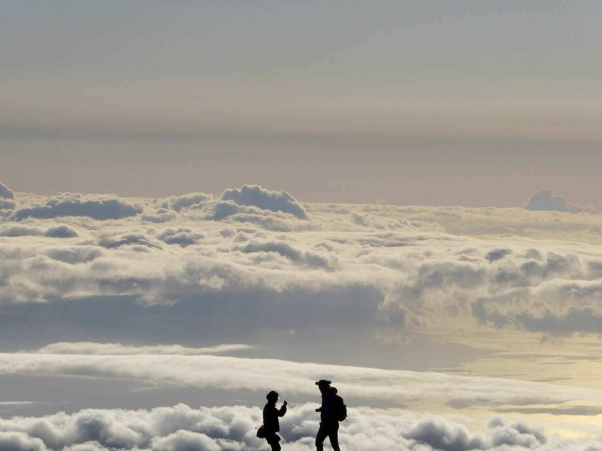 cloud silhouette of two people overlooking clouds during daytime sky