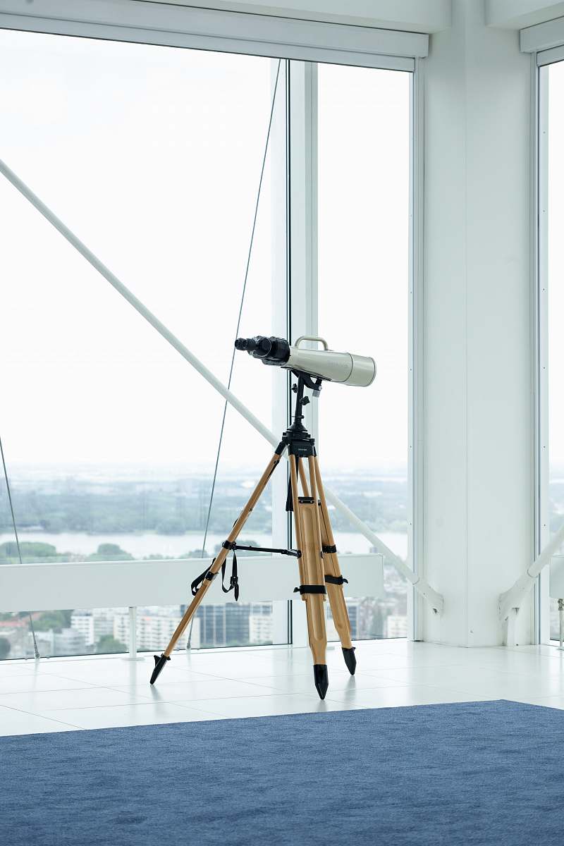 interior silver telescope beside glass window tripod