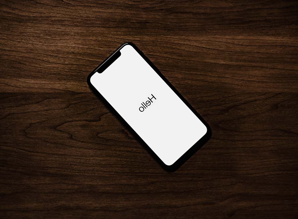 phone turned on iPhone on top of brown wooden surface iphone
