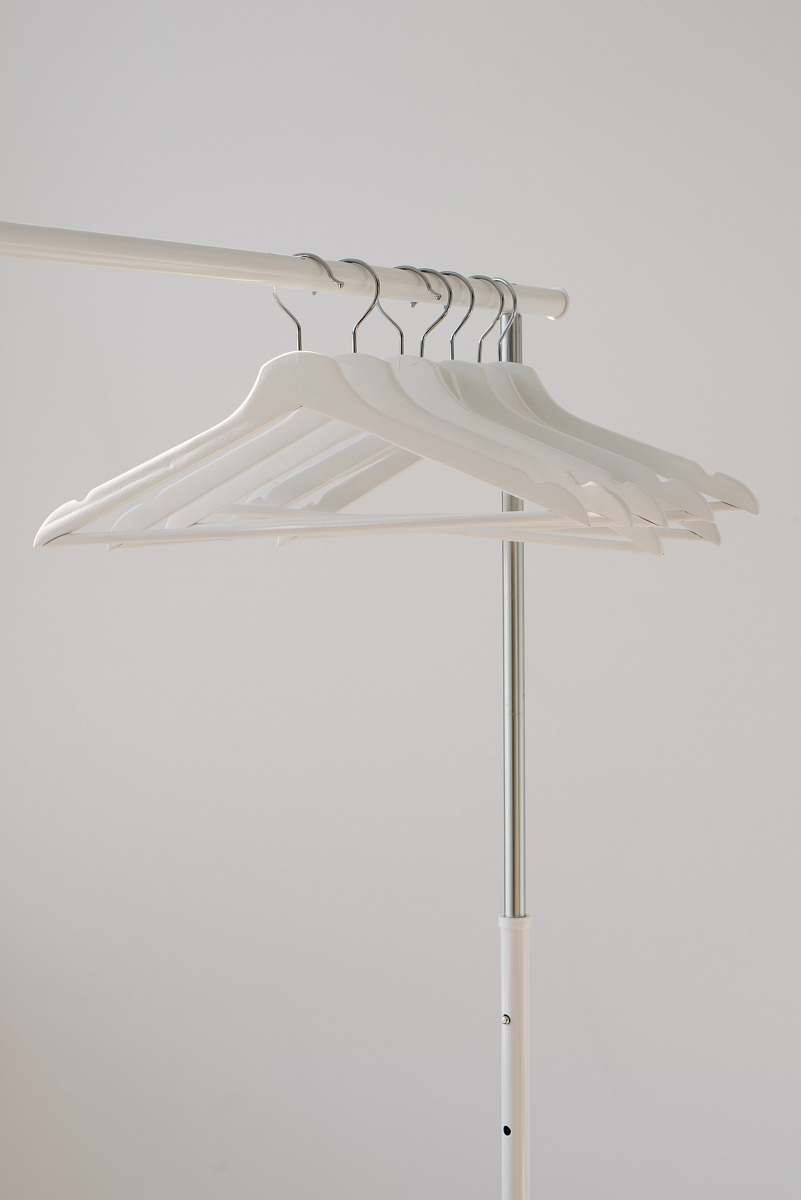 grey white clothes hangers hanging on rack home