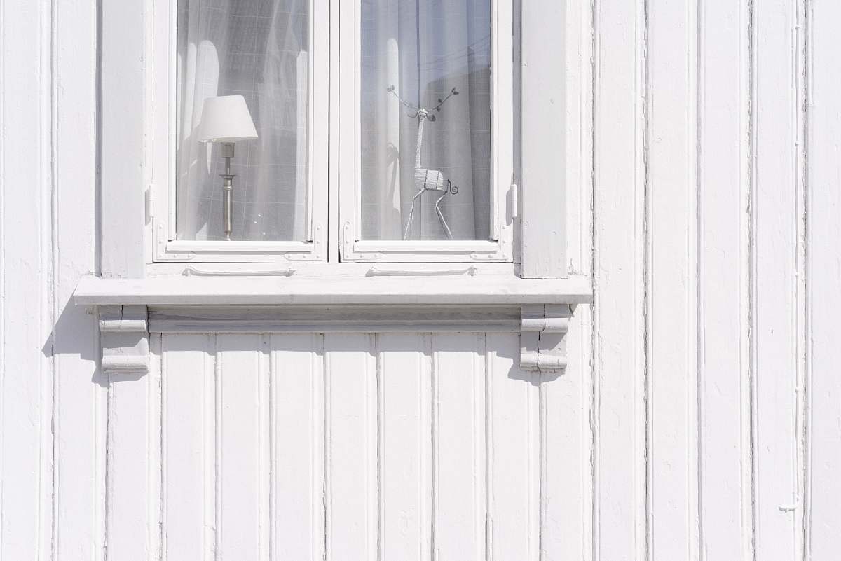 norway white wooden wall cabinet with figurine and table lamp inside light