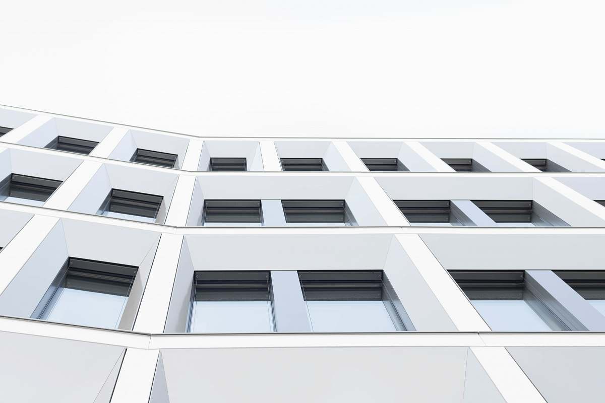building worm's eyeview photo of white concrete 3-storey building window